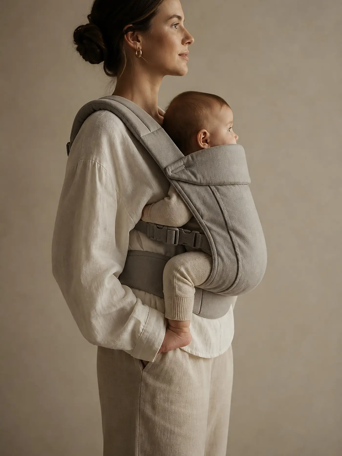 Mujer de perfil porteando a su bebé, fotografía de campaña